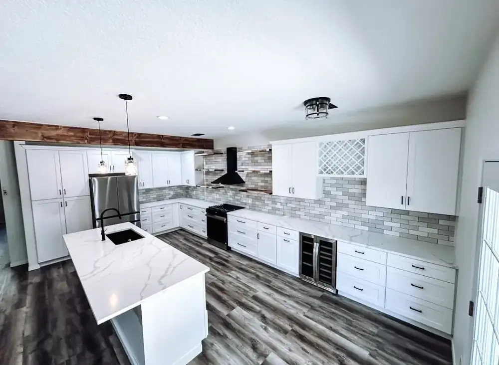 Bright open-concept remodeled kitchen with white quartz island, black fixtures, and French doors to the backyard
